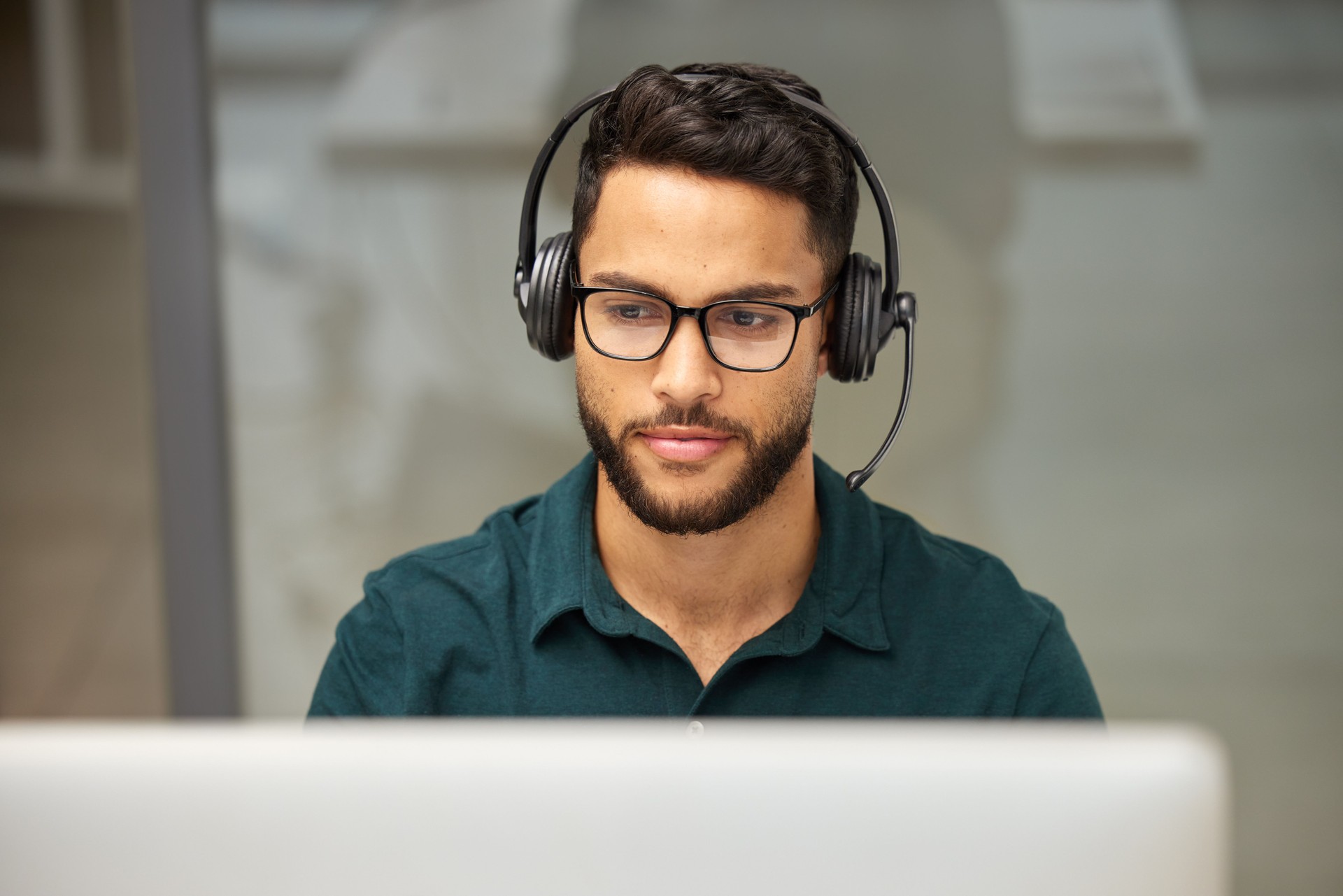 Shot of a businessman using a computer while working in a call center